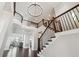 Bright and airy foyer showcasing a staircase with dark wood accents and a view to the upper level at 4440 Croftshire Pl, Cumming, GA 30040