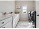 Spacious laundry room features tile flooring and sleek, modern appliances at 4440 Croftshire Pl, Cumming, GA 30040
