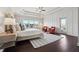 Bright main bedroom featuring hardwood floors, tray ceilings, and an exterior door to the balcony at 4440 Croftshire Pl, Cumming, GA 30040
