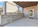 This covered patio has brick walls, wood ceiling, concrete floor and a glass door at 4440 Croftshire Pl, Cumming, GA 30040