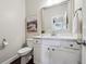 Stylish powder room with a white vanity, quartz countertop, and decorative mirror at 4440 Croftshire Pl, Cumming, GA 30040