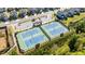 Aerial view of the community tennis courts with blue playing surface and lighting at 4440 Croftshire Pl, Cumming, GA 30040