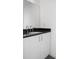 Contemporary powder room featuring a sleek vanity with a black countertop and white cabinets at 455 Glen Iris Ne Dr # D, Atlanta, GA 30308