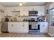 Well-lit kitchen featuring white cabinets, stainless steel appliances, and modern finishes at 1050 Wedgewood Ln, Tucker, GA 30084