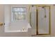 Bathroom featuring a soaking tub, a shower, and natural light from a nearby window at 1413 Eastbrooke Way, Marietta, GA 30066