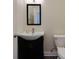 A half bathroom features a dark vanity, modern sink, mirror, and toilet with neutral wall paint at 1413 Eastbrooke Way, Marietta, GA 30066