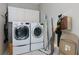 Practical laundry room with white cabinets and modern washer and dryer at 1413 Eastbrooke Way, Marietta, GA 30066