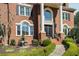 Close-up of a brick home with manicured hedges, decorative fountain, and ornate front door at 5400 Saint Lyonn Pl, Marietta, GA 30068