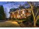Elegant two-story brick home with grand columns, manicured lawn, and illuminated landscaping at twilight at 5400 Saint Lyonn Pl, Marietta, GA 30068