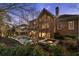 Rear exterior featuring pool and fountains surrounded by decorative stone, manicured lawn and multiple windows at 5400 Saint Lyonn Pl, Marietta, GA 30068