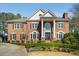Stately brick home featuring a manicured lawn, mature landscaping, and classic architectural details at 5400 Saint Lyonn Pl, Marietta, GA 30068