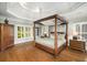 Spacious main bedroom with a four-poster bed, hardwood floors, and tray ceiling at 5400 Saint Lyonn Pl, Marietta, GA 30068