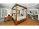 Luxurious main bedroom with a four-poster bed, hardwood floors, and ample natural light at 5400 Saint Lyonn Pl, Marietta, GA 30068