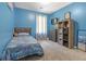 Cozy blue bedroom with a single bed, soft carpet, natural light, and ample storage at 7158 Georges Way, Morrow, GA 30260