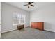 A clean bedroom with gray carpet and a large wooden dresser near a window at 1784 Treymire Ct, Stone Mountain, GA 30088