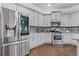 The stainless steel refrigerator and appliances complement the gray cabinetry and granite countertops in this modern kitchen design at 1784 Treymire Ct, Stone Mountain, GA 30088