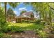 Expansive backyard showcasing a charming two-story home, lush landscaping, and inviting swing at 2802 Nettle Ln, Buford, GA 30519