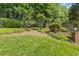 Landscaped backyard with manicured shrubs, flowers, brick accents, and a well-maintained lawn, enhancing curb appeal at 2802 Nettle Ln, Buford, GA 30519