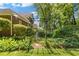 Landscaped backyard featuring a charming pergola, lush greenery, and a stone pathway at 2802 Nettle Ln, Buford, GA 30519