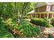 Brick home showcasing lush landscaped grounds, complete with a tranquil stream and mature trees at 2802 Nettle Ln, Buford, GA 30519