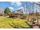 Charming backyard with lush lawn, mature trees, and a cozy wooden swing set for outdoor relaxation at 2802 Nettle Ln, Buford, GA 30519