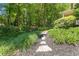 Beautiful backyard featuring a stone pathway, vibrant roses, and lush landscaping at 2802 Nettle Ln, Buford, GA 30519