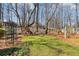 Large backyard with green lawn, mature trees, and a charming swing set, creating a relaxing outdoor space at 2802 Nettle Ln, Buford, GA 30519