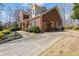 Brick home with a long driveway, lush landscaping, and charming architectural details at 2802 Nettle Ln, Buford, GA 30519