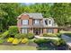 Classic brick home featuring manicured front yard with lush landscaping and charming shutters at 2802 Nettle Ln, Buford, GA 30519