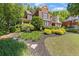 Traditional brick home featuring manicured lawn, mature trees, and tidy landscaping at 2802 Nettle Ln, Buford, GA 30519