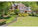 Charming two-story brick home with lush landscaping and a covered front porch at 2802 Nettle Ln, Buford, GA 30519