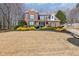 Traditional brick home with a manicured lawn, garden beds, and inviting front entrance at 2802 Nettle Ln, Buford, GA 30519