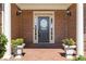 Elegant brick home entrance with white columns and potted flowers on a brick porch at 2802 Nettle Ln, Buford, GA 30519