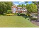 Well-maintained front yard with lush green lawn and mature trees surrounding a brick home at 2802 Nettle Ln, Buford, GA 30519