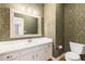 Charming powder room with decorative wallpaper and white vanity at 2802 Nettle Ln, Buford, GA 30519
