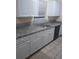 A kitchen with white cabinets, gray granite countertops, tile backsplash and stainless steel sink at 1085 Mainstreet Valley Dr, Stone Mountain, GA 30088