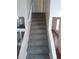 Carpeted stairs leading up to the next floor with view into the next room and the kitchen at 1085 Mainstreet Valley Dr, Stone Mountain, GA 30088