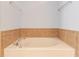 Close-up of a soaking tub with tile surround, perfect for relaxing after a long day at 2033 Fosco Dr, Duluth, GA 30097