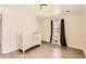Bright bedroom featuring hardwood floors, neutral walls, and a white baby crib at 3045 Riviera Nw Dr, Conyers, GA 30012