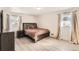 Cozy bedroom with large windows, neutral-toned walls, hardwood flooring, and a comfortable queen-sized bed at 3045 Riviera Nw Dr, Conyers, GA 30012