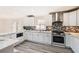 Charming kitchen boasts white cabinets, marble countertops, mosaic backsplash, and stainless steel appliances at 3045 Riviera Nw Dr, Conyers, GA 30012