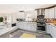 Charming kitchen boasts white cabinets, marble countertops, mosaic backsplash, and stainless steel appliances at 3045 Riviera Nw Dr, Conyers, GA 30012
