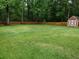 Large, grassy backyard with a privacy fence and storage shed at 401 Peggy Ln, Villa Rica, GA 30180