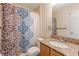 Bathroom featuring a granite countertop, wood cabinets, patterned shower curtain and a toilet at 7238 Hummingbird Ln, Winston, GA 30187