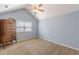 Bedroom with light blue walls, a ceiling fan, tan carpet, and a wooden dresser near the window at 7238 Hummingbird Ln, Winston, GA 30187