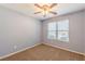 A carpeted bedroom featuring a ceiling fan and natural light from a window at 7238 Hummingbird Ln, Winston, GA 30187