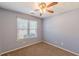 Bedroom features neutral walls, brown carpeting, and a window that brings in natural light and fresh air at 7238 Hummingbird Ln, Winston, GA 30187