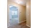 Hallway leading to a carpeted bedroom with blue walls, a ceiling fan, and a window at 7238 Hummingbird Ln, Winston, GA 30187