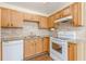 The bright kitchen includes light wood cabinets, stone-look countertops, and white appliances at 7238 Hummingbird Ln, Winston, GA 30187