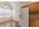 This eat-in kitchen features wood cabinets, a white refrigerator, and bright natural light at 7238 Hummingbird Ln, Winston, GA 30187